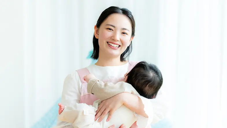 赤ちゃんを抱いているスタッフが笑顔で撮影してもらっている様子