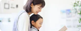 保育士が子どもと絵本を読んでいる様子