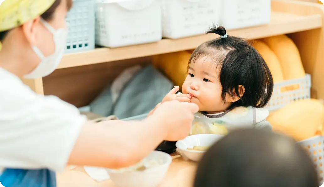 スタッフが子どもに食事を与えている様子