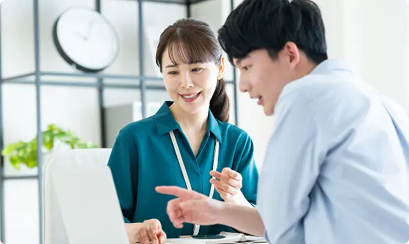 ノートパソコンを囲んで話し合うスタッフの様子